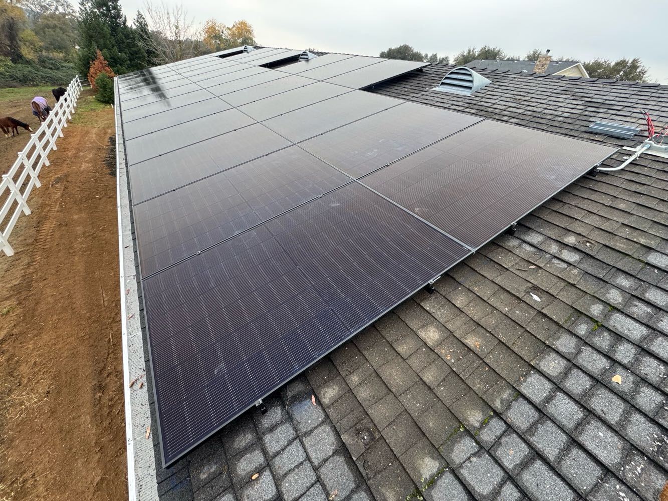 Residential solar installation — black panels on ranch property roof
